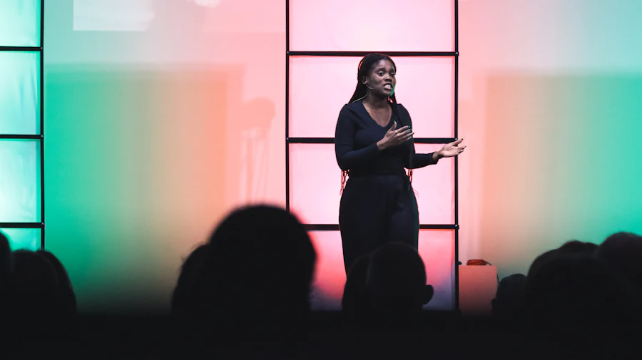 A speaker addressing an audience from a lit stage